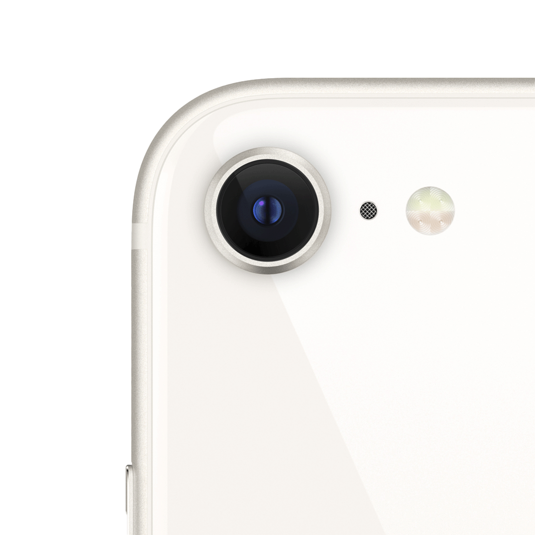 Vista en primer plano del módulo de cámara trasera del iPhone SE en color blanco estelar. Se aprecia una única lente circular, el micrófono y el flash LED, integrados en la esquina superior izquierda de la parte trasera del dispositivo.